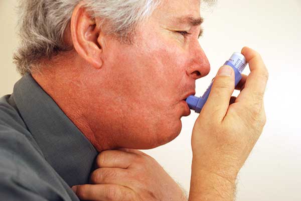Asthmatiker verwendet Inhalator bei Asthmaanfall