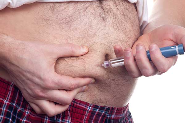 Diabetiker mit Übergewicht spritzt Insulin