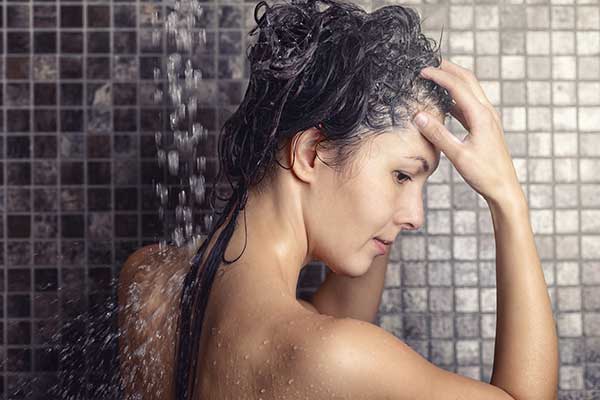 Frau wäscht ihre Haare mit Schungit-Wasser